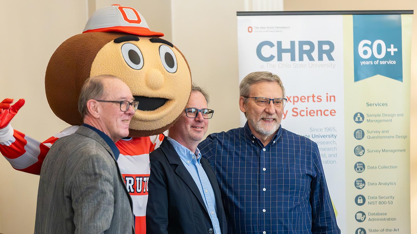 Brutus Buckeye poses with CHRR Associate Director Josh Hawley and his 2 colleagues at CHRR's 60th anniversary breakfast party